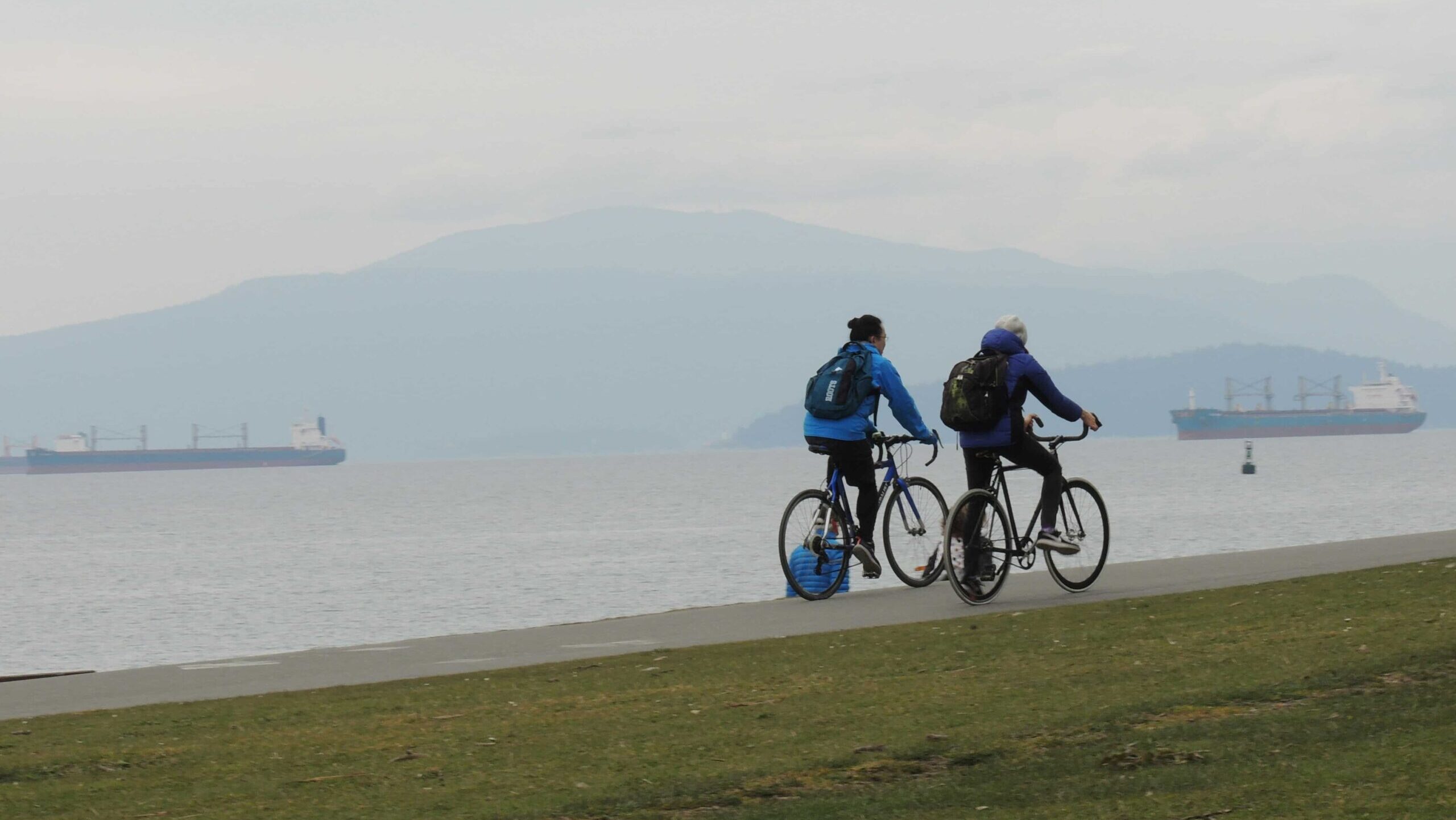 Two cyclists biking along the seawall in Vancouver